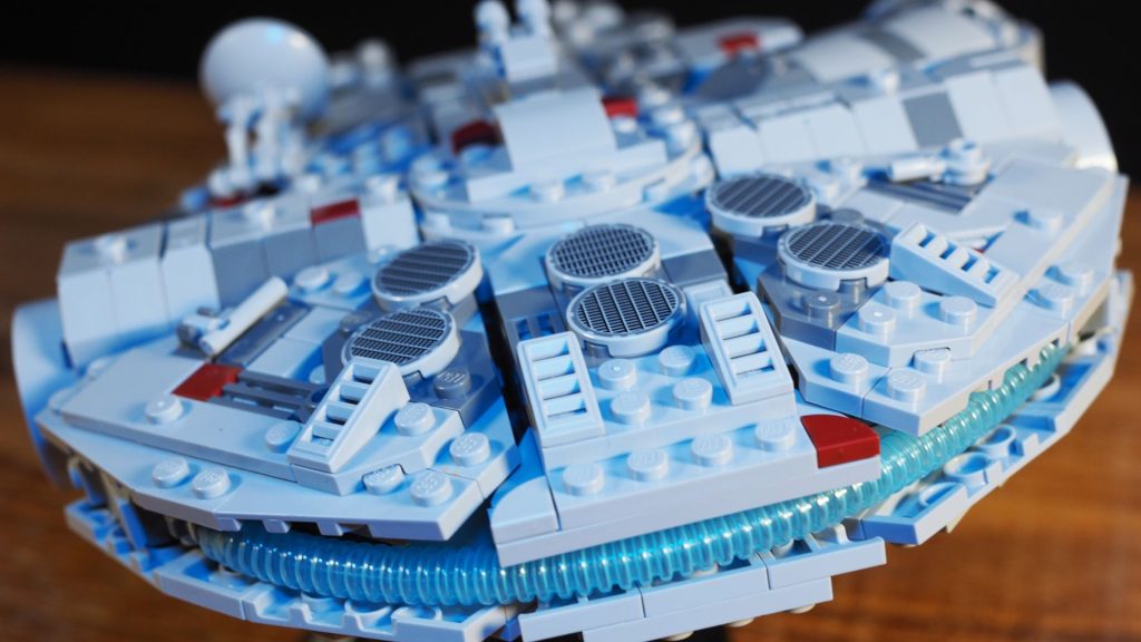 We're getting a new Lego Millennium Falcon, but this time there's a twist Lego Millennium Falcon set laid out on a wooden surface