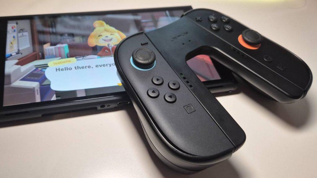 The JSAUX Switch 2 Charging Grip managed to finally make me see the docked mode light | Review Photo of a pair of Switch 2 Joy-Con resting on the handheld with the Charging Grip attached.