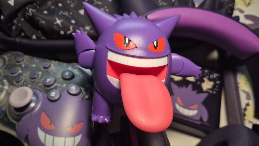 Photo of a Gengar toy sitting on a pile of Razer and Hori gaming accessories.