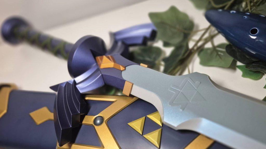 Close up of the Proplica Master Sword by Bandai sitting on a white desk.