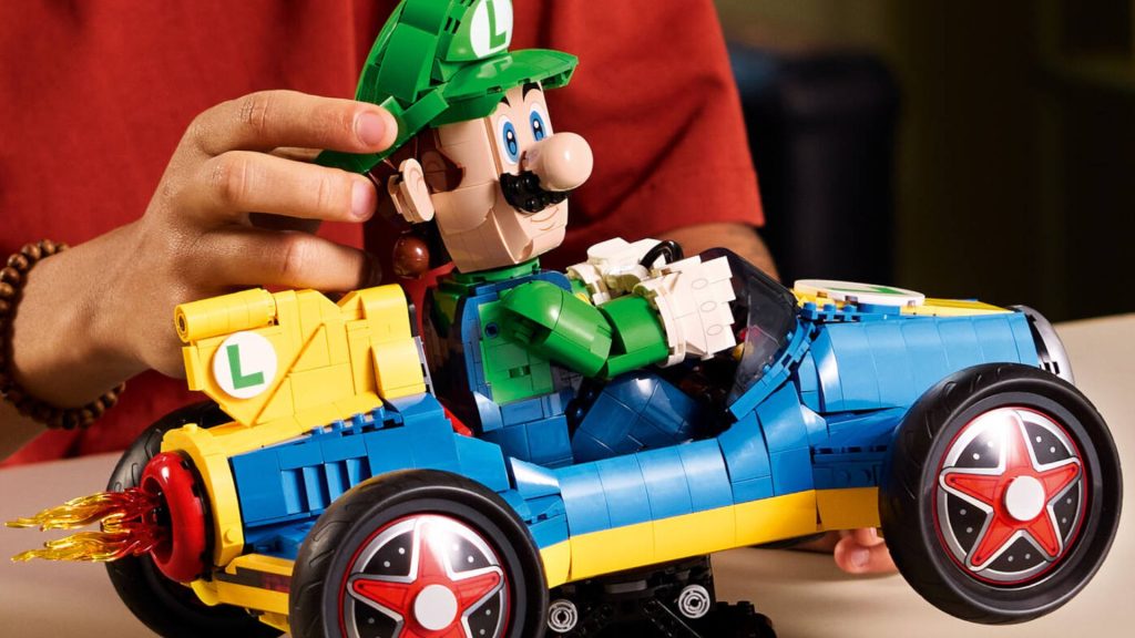 A hand poses Lego Luigi's head