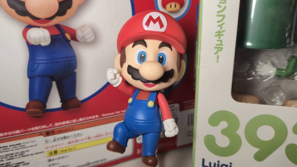 Photo of the Super Mario Nendoroid figure sitting infront of some figure boxes.