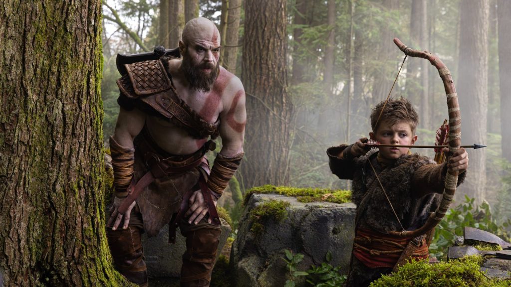 Ryan Hurst's Kratos crouching near Atreus (Callum Vinson) in first look at God of War series