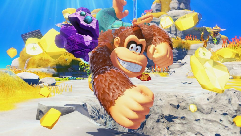 Donkey Kong Bananza screenshot of Donkey Kong punching through the landscape with pieces of banana flying through the air