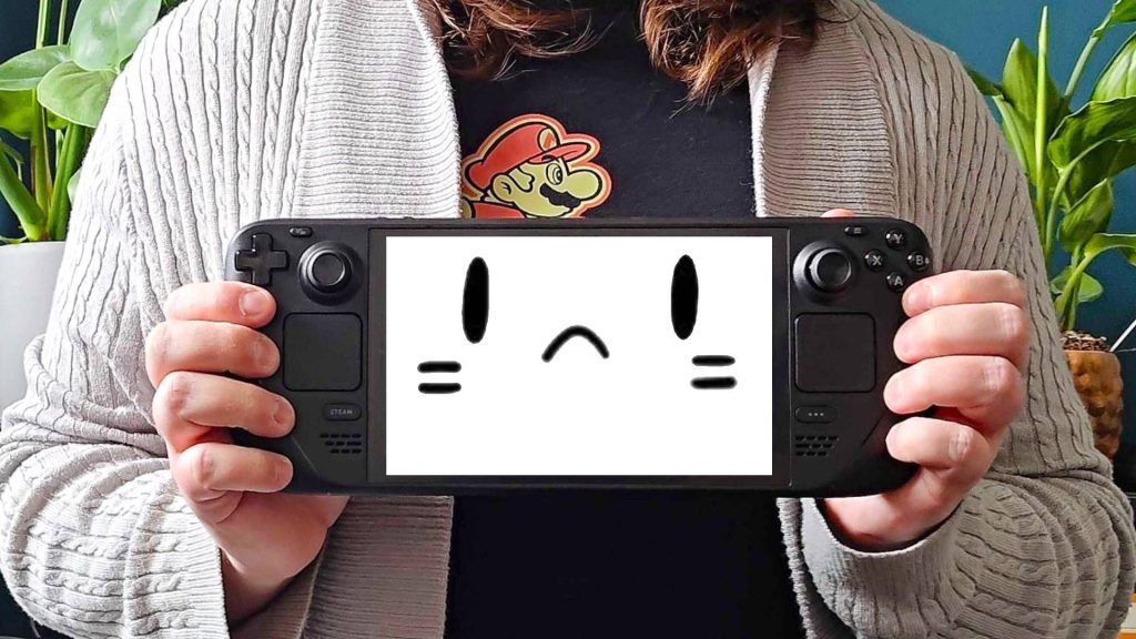 Phil Hayton holding Steam Deck OLED with mascot face on screen with thrown.