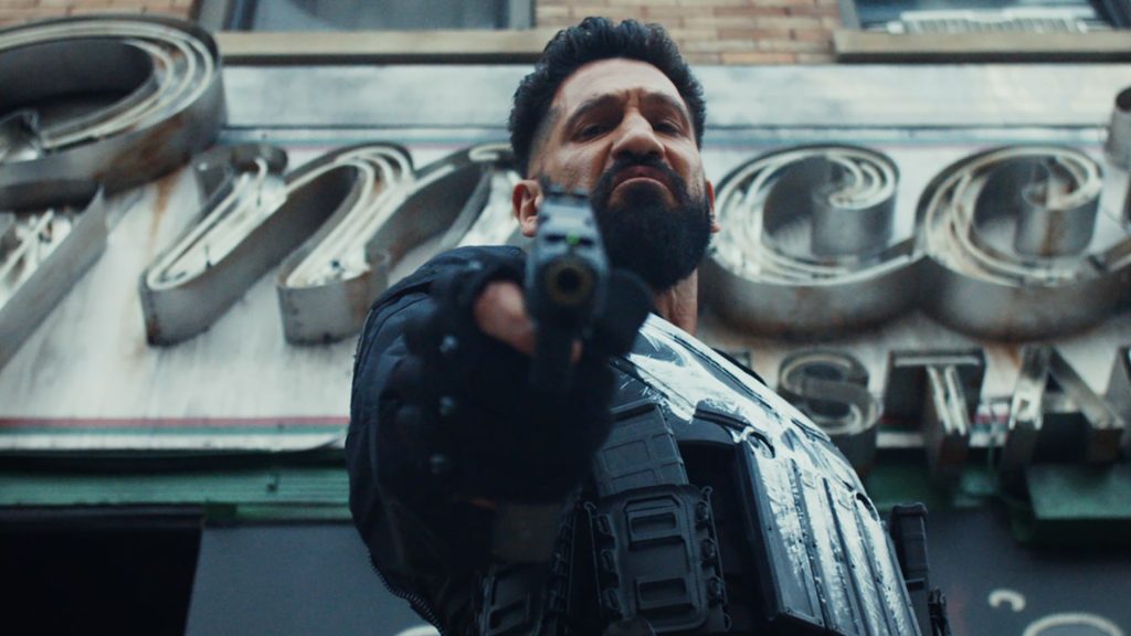 Jon Bernthal as Frank Castle aiming a gun at the camera