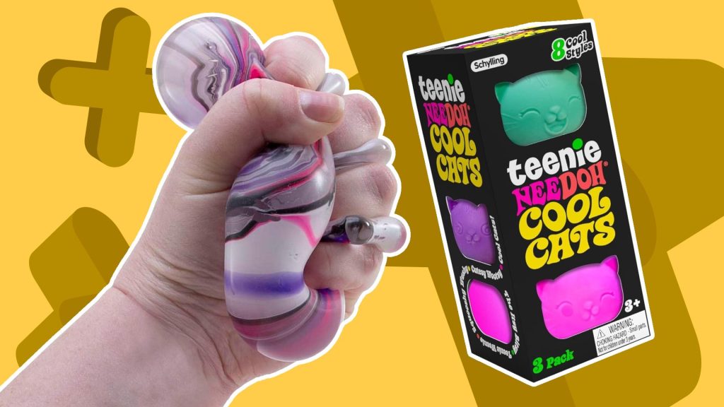 A hand squeezing NeeDoh beside a box of Cool Cats