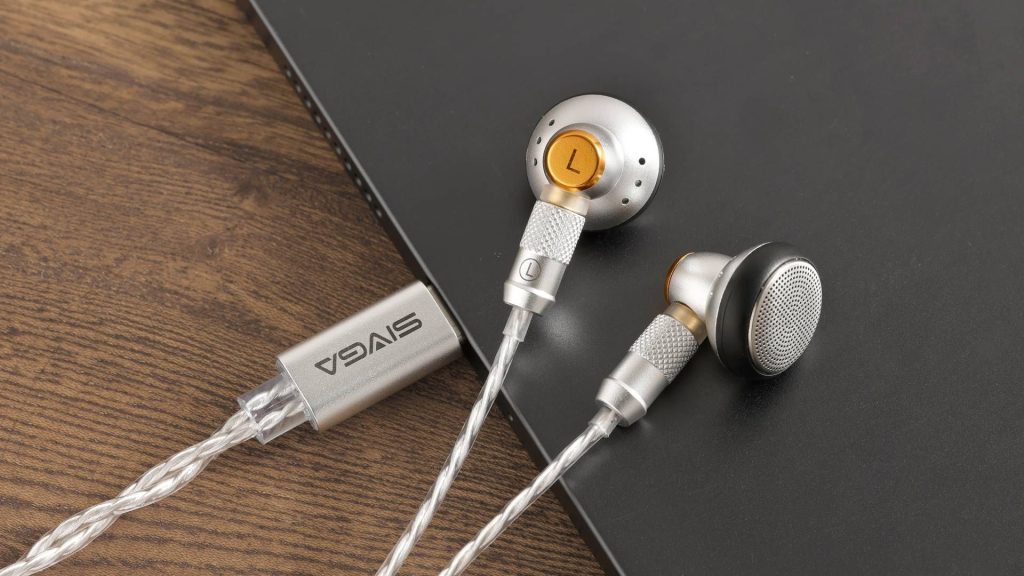 Image of the SIVGA M260 earbuds sitting on a wooden gaming desk.
