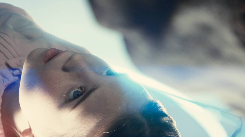 Disclosure Day is the third film in a "sort of trio" with Close Encounters of the Third Kind and E.T., says star A young girl looking up at an alien in Disclosure Day